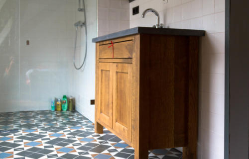 massief eiken badkamer meubel gebeitst landelijke uitstraling met zwart betonnen werkplat en keramiek spoelbak